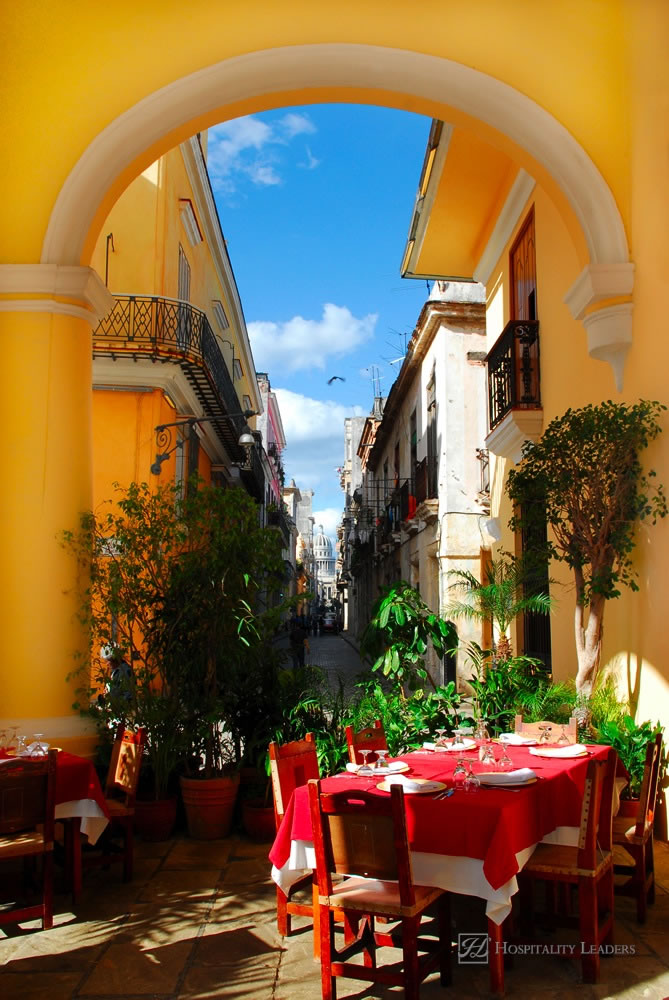 Traditional restaurant exterior with table settings on the terrace and view on old havana at caribbean island Cuba