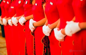 Hospitality News: Chinese waitress dressed neatly in red cheongsam and white glove, standing in a row