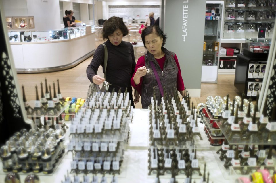 Chinese tourists look at Eiffel Tower souvenirs at the Galeries Lafayette shopping center in Paris.