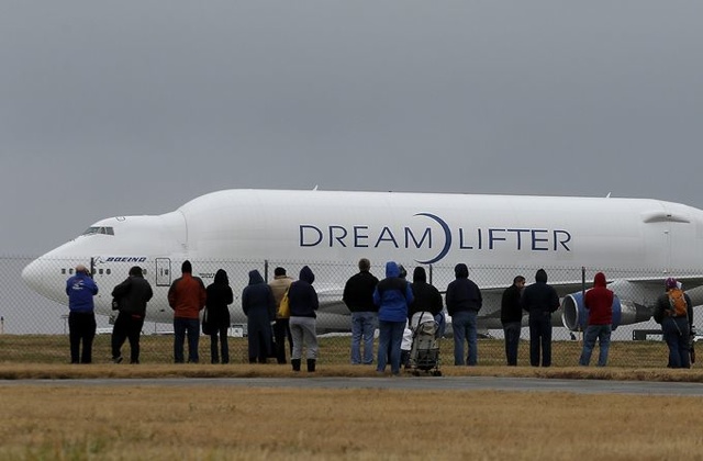 People watch a Boeing 747 Dreamlifter cargo aircraft on a runway at Col. James Jabara Airport in Wichita.  Charlie Riedel, AP